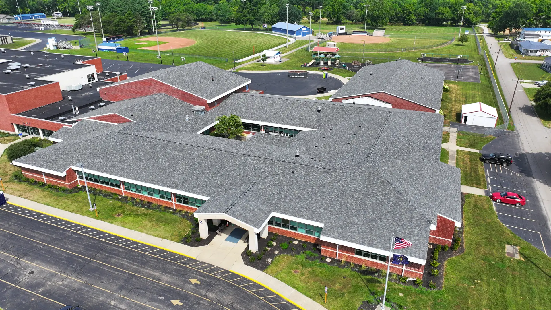 Aerial view of a large school building with newly installed commercial roofing in Indiana