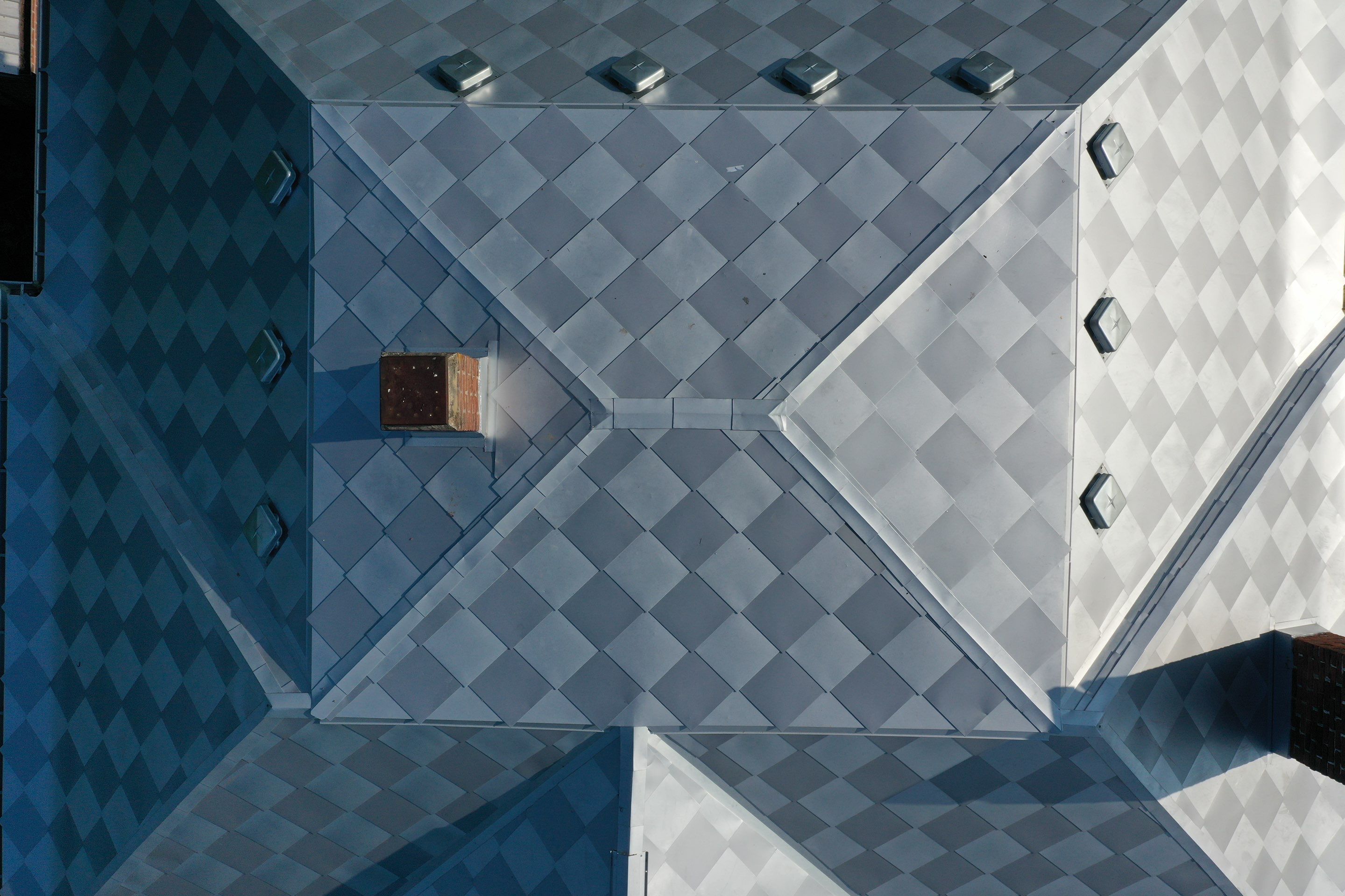 Two color diamond pattern metal roof after fire restoration