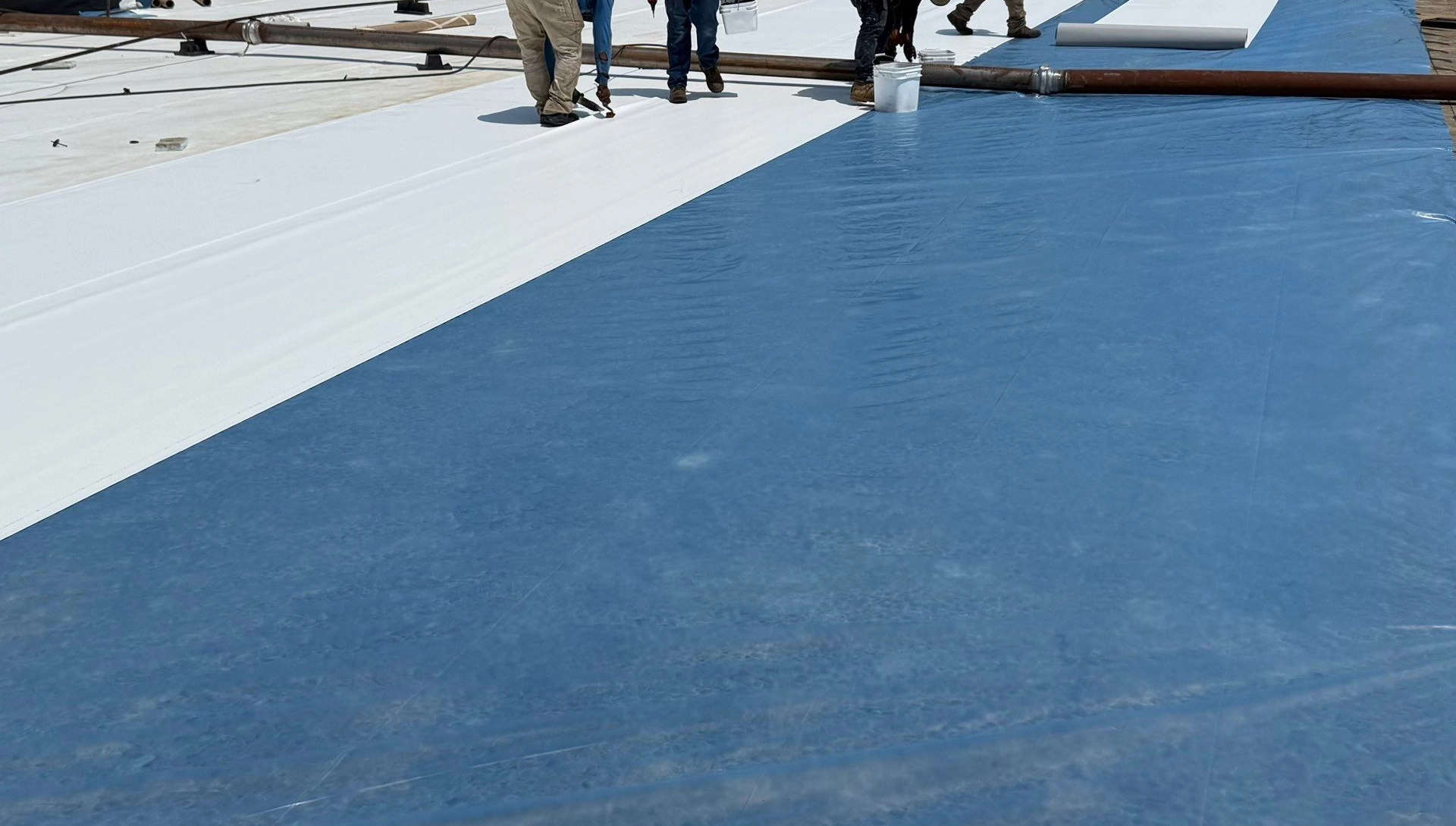 Blue deck sheet and white durolast membrane staged side by side
