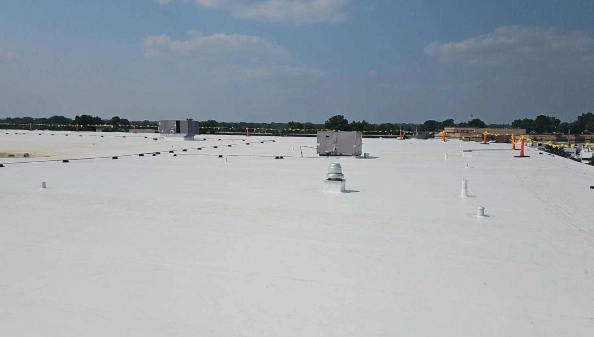 Wide shot of a durolast roof with rooftop units under a clear sky